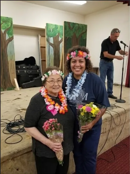 Clients and caregiver at a luau celebration with flower leis
